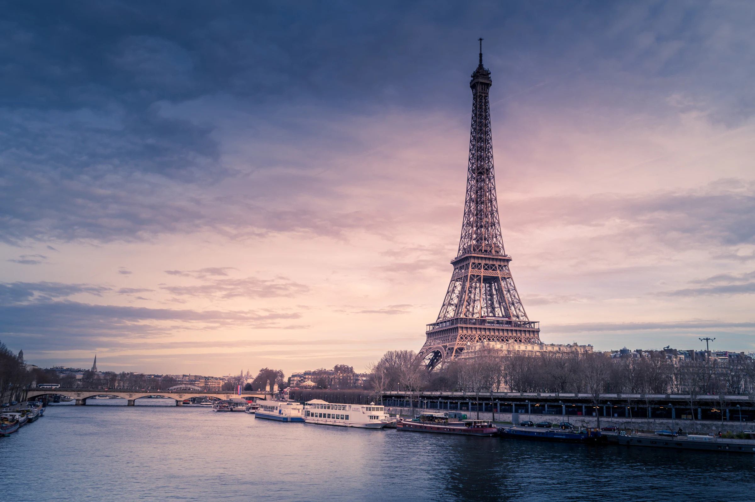 The Eiffel Tower over the Seine at dusk in Paris