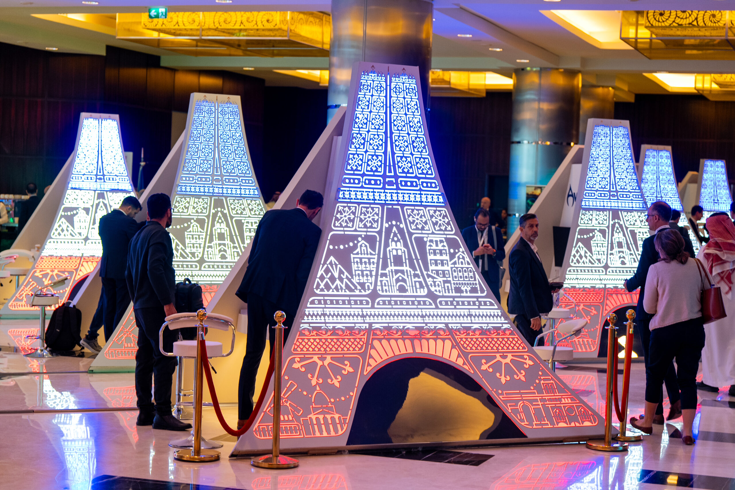 The French face of the towers, lit blue, white and red, with guests in the foyer