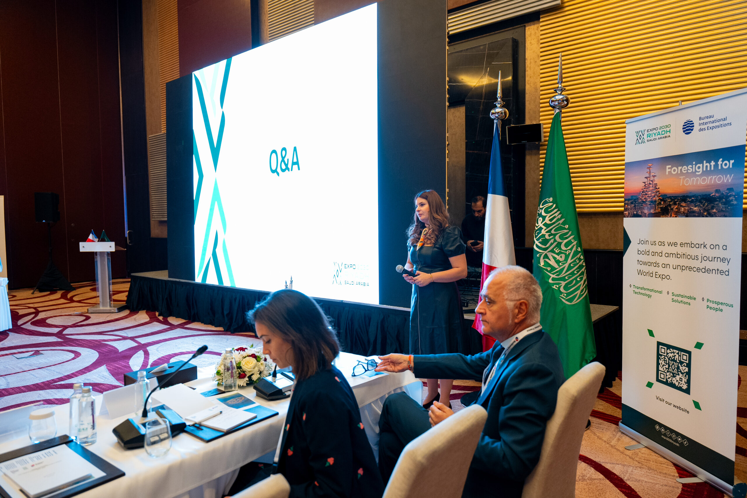 A Q&A session at the French-Saudi Business Forum, beneath the French and Saudi flags